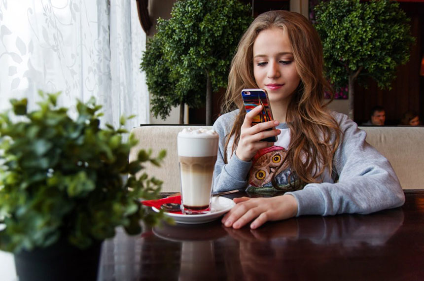 young woman with cellphone in cafe