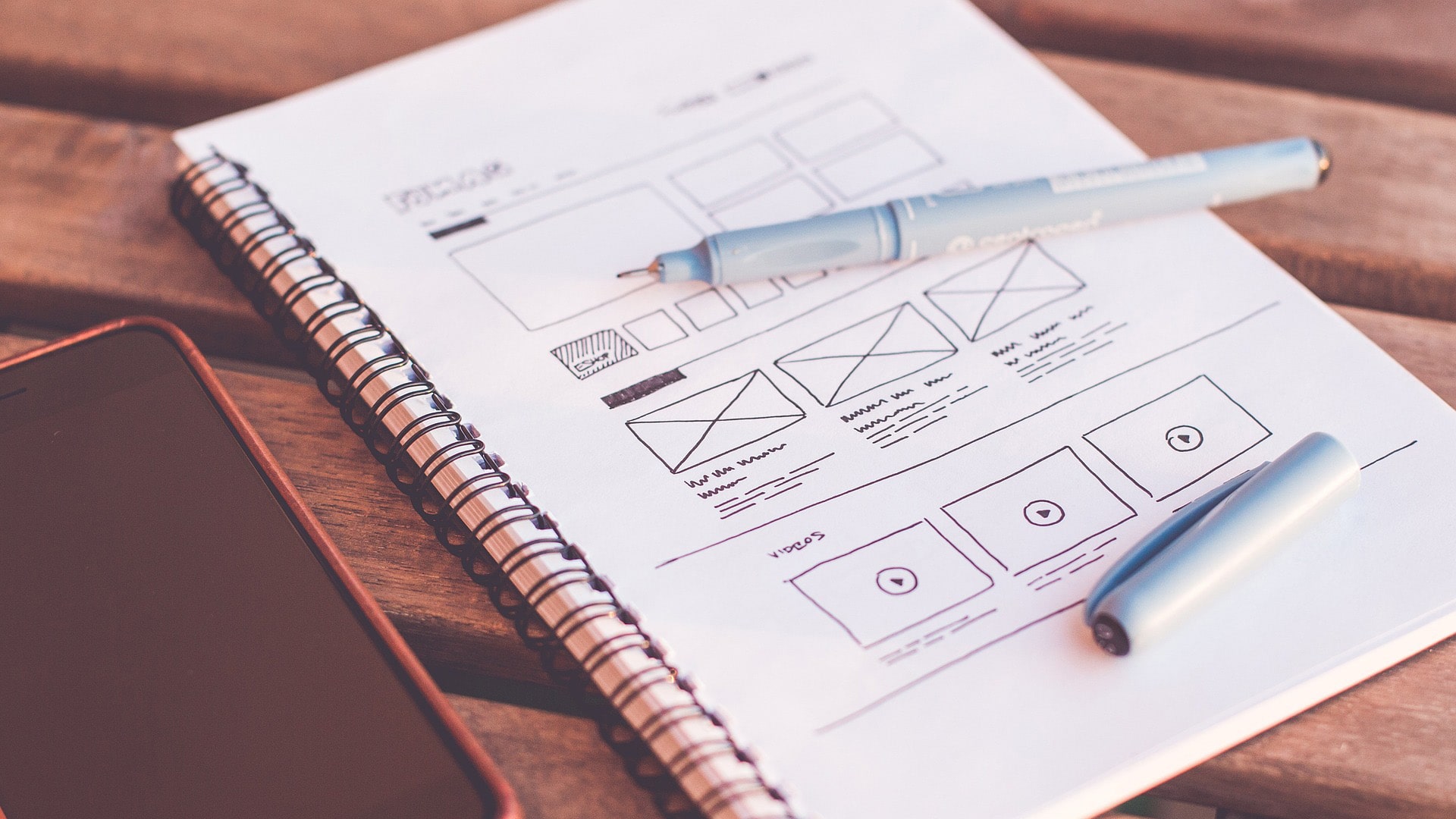 pen on notebook displaying a website wireframe example